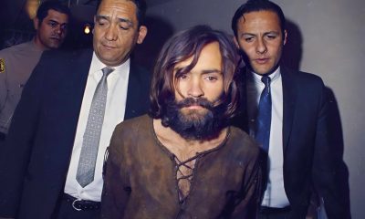 Charles Manson is escorted to his arraignment on conspiracy-murder charges