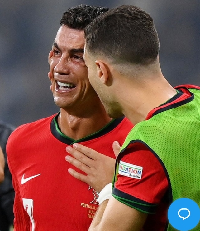 Cristiano Ronaldo being consoled by Diogo Dalot after the game.